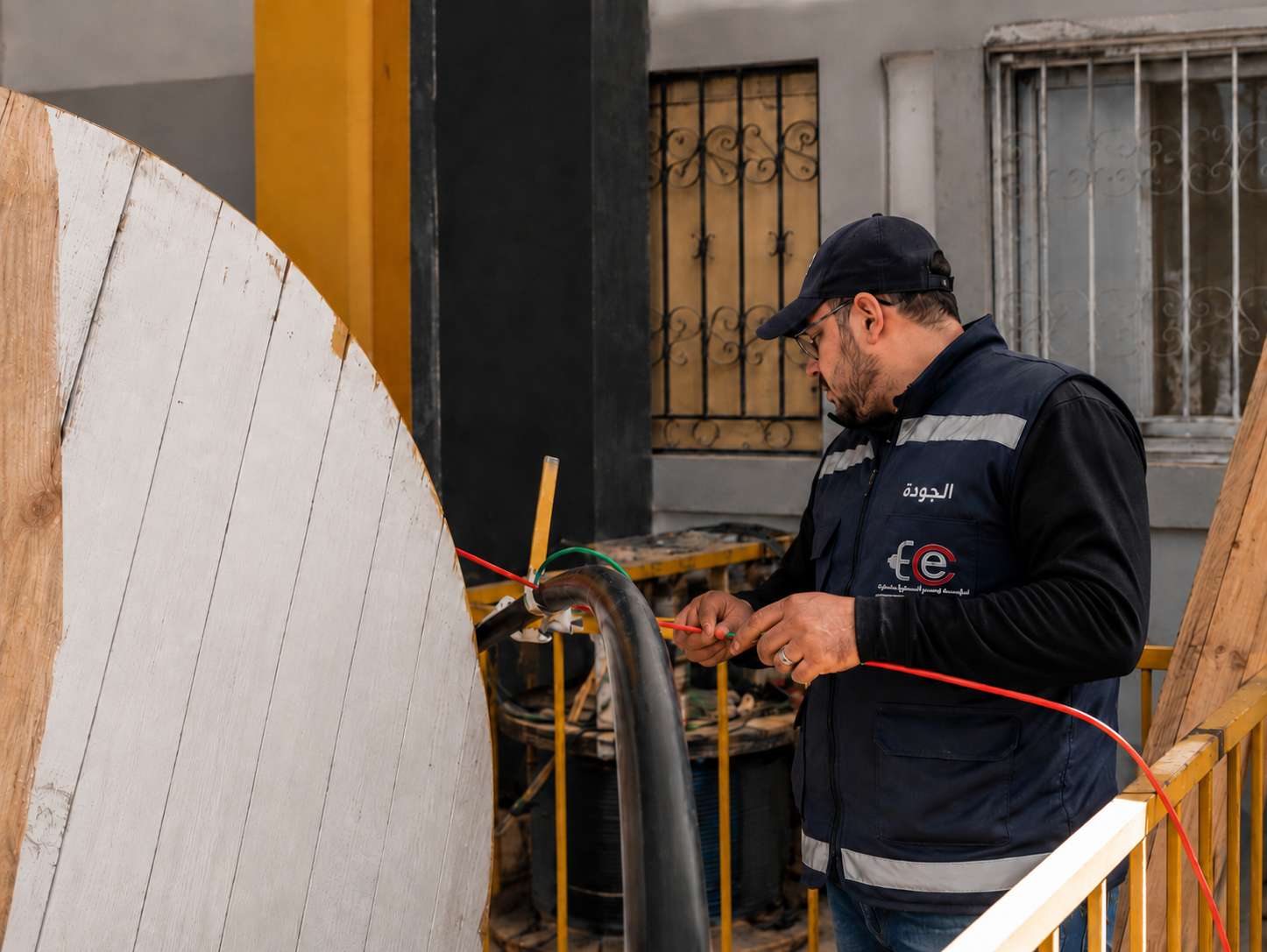 فني الجودة يفحص توصيلات كابل كهربائي داخل المصنع